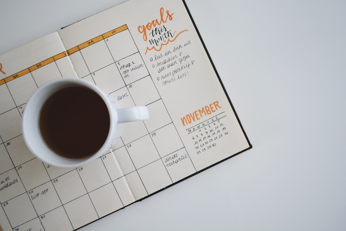 An open paper planner and pen resting on a desk